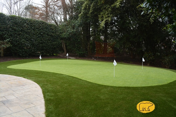 Austin Synthetic grass golf green with 4 holes and flags in a landscaped backyard