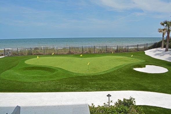 Austin Synthetic grass golf green by the sea with yellow flags and a sand bunker